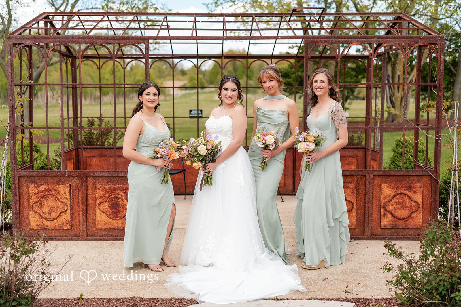 Group photo of bride with bridesmaids holding bouquets at Venue 5126