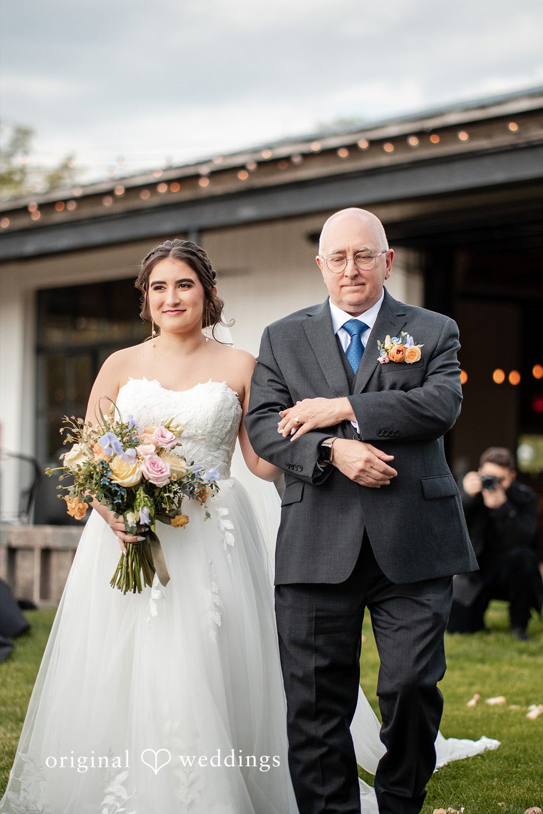 Beautiful bride walking down the aisle arms in arms for wedding ceremony.