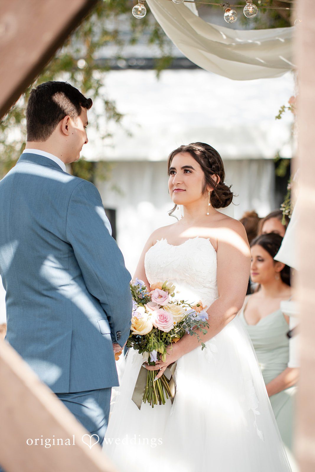 Bride and groom exchanging vows during an outdoor wedding ceremony.