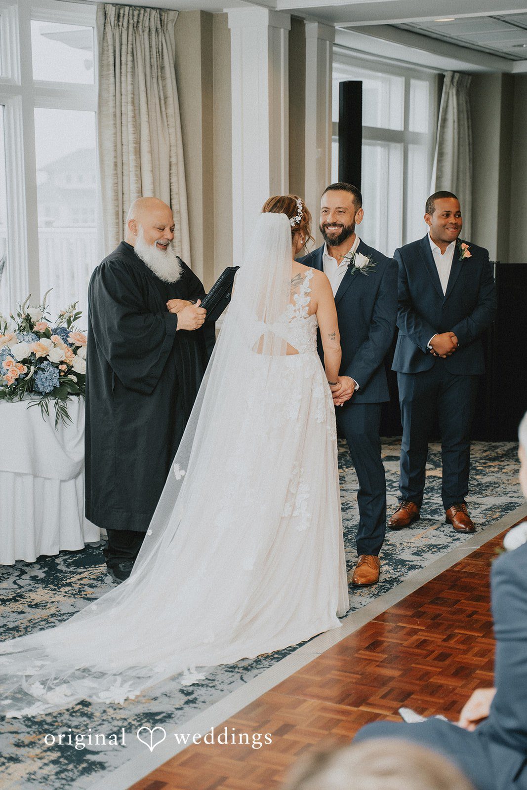 Taylor + David Bride viewed from behind as the groom smiles during the ceremony