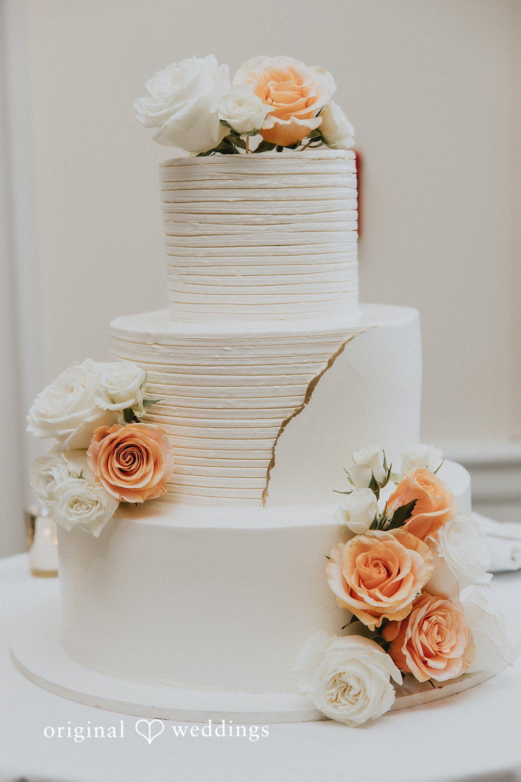 An all-white wedding cake adorned with fresh blooms