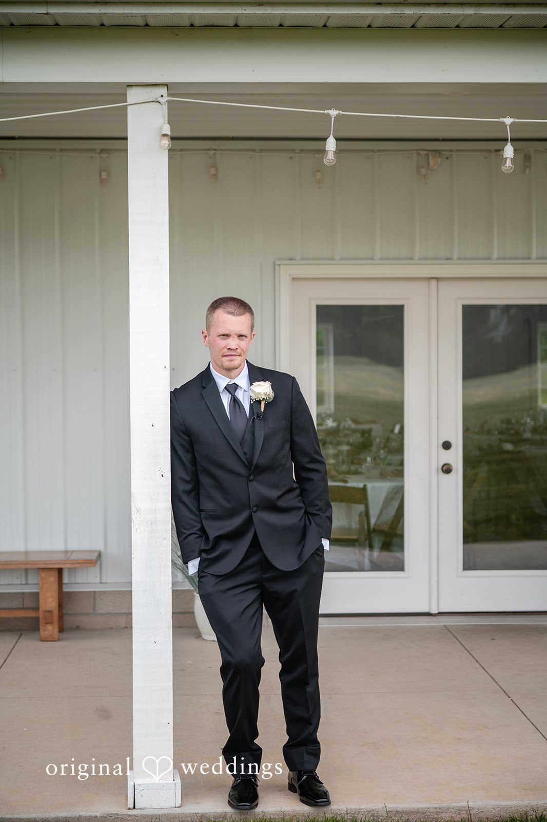 Lauren + Ron The groom poses in front of the barn