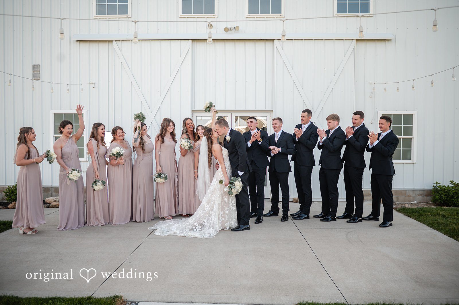 Lauren + Ron Our Cleveland wedding photographers captured a romantic portrait of the couple with cheers from their bridal party at the White Rose Barn