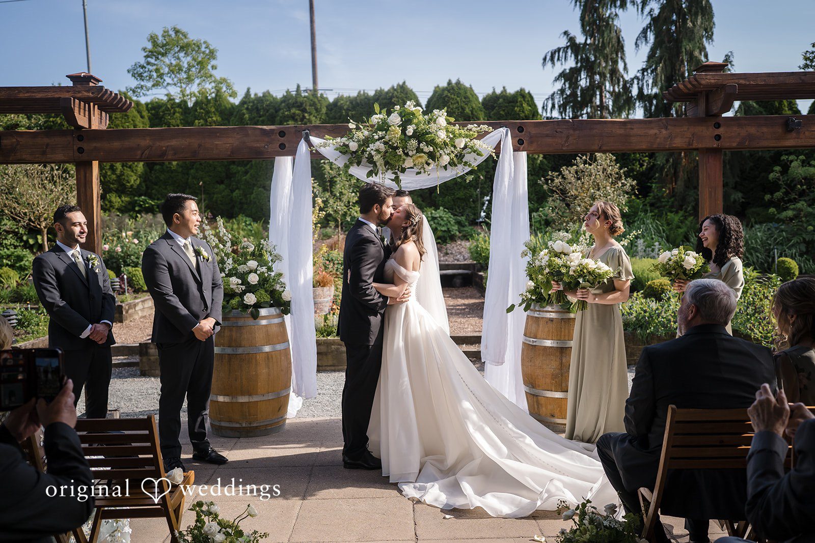 Romantic first kiss shared by bride and groom after wedding ceremony at Willows Lodge