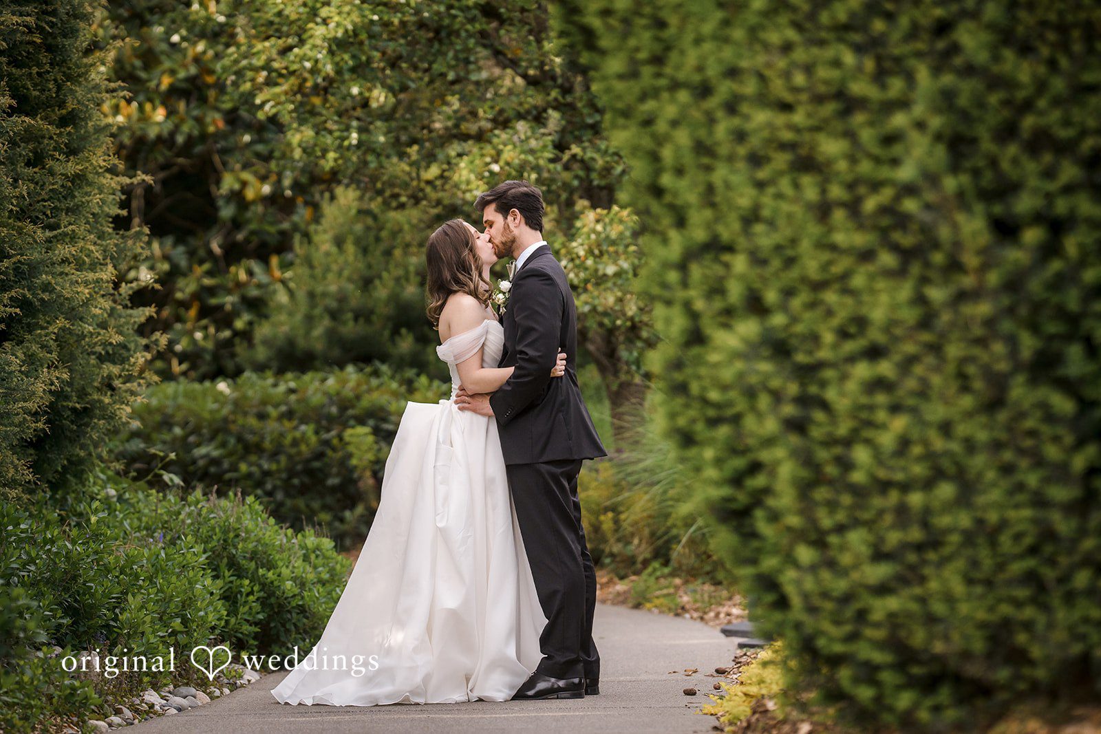 Lovely couple sharing a kiss while posing for wedding photography