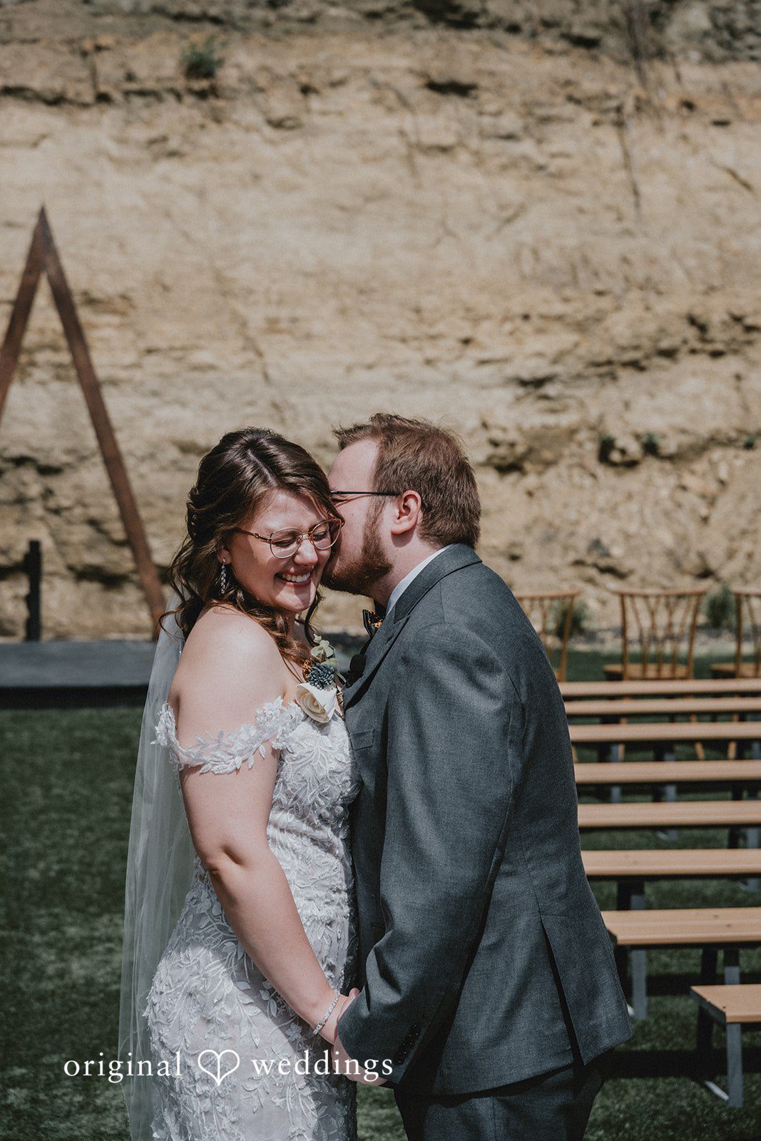 Ashlee + Colby Bride and groom posing together inside the empty reception hall