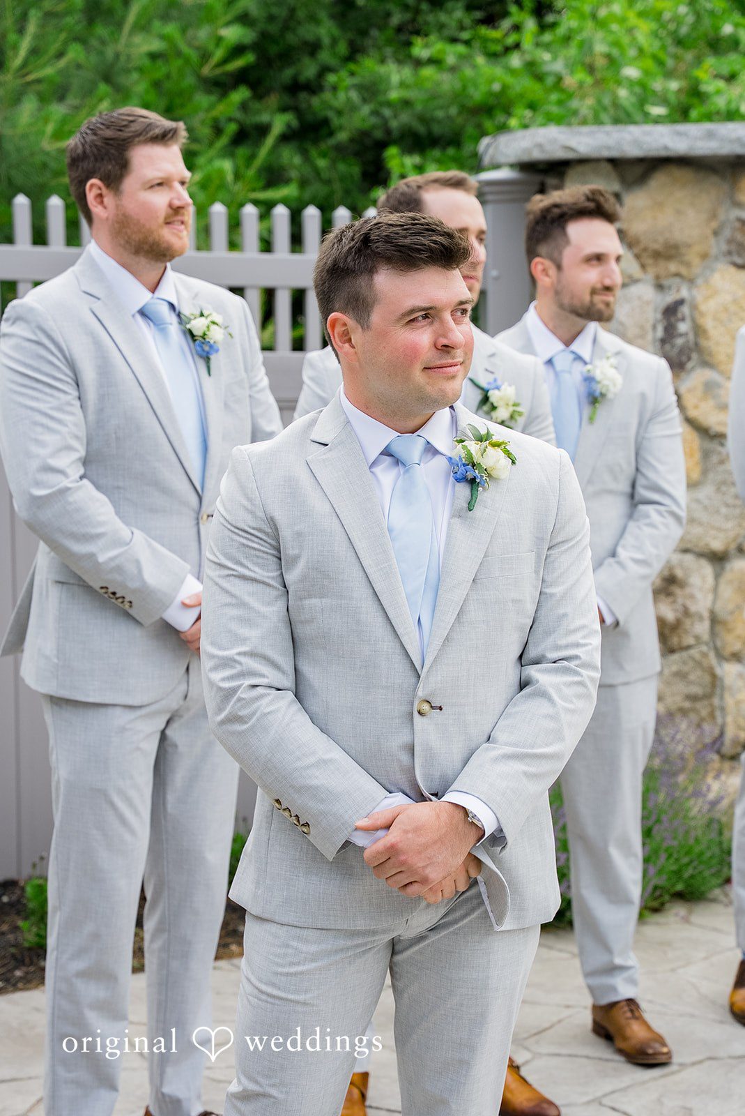 Molly + Joe A groom and his groomsmen laugh and walk together on a paved path.