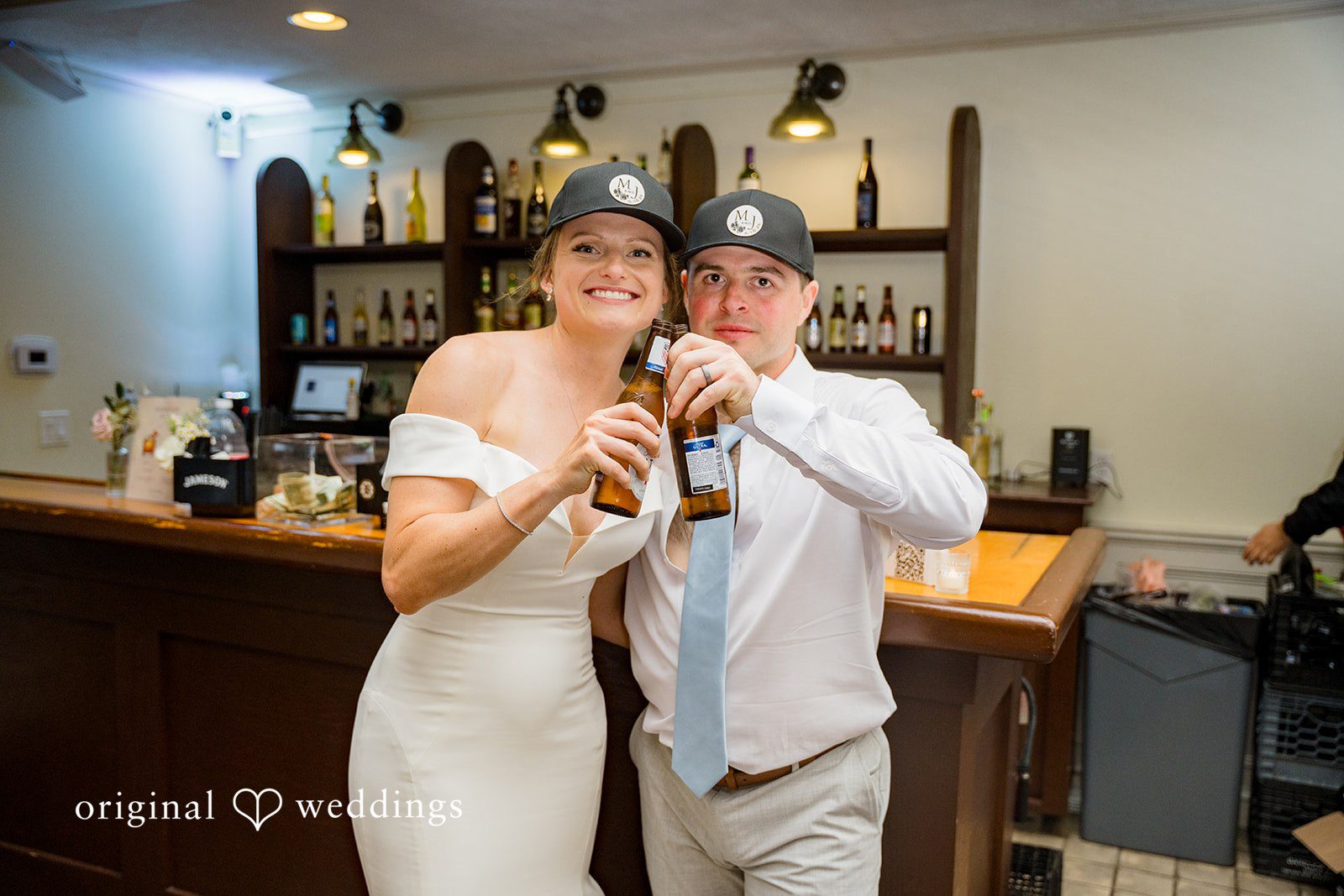 Molly + Joe A bride and groom raise their glasses for a toast at a bar counter.