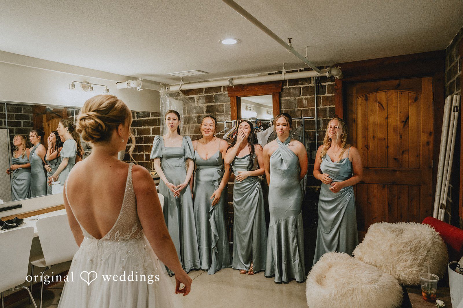 Neil + Hallie A bride standing with her bridesmaids who are wearing dusty blue dresses.