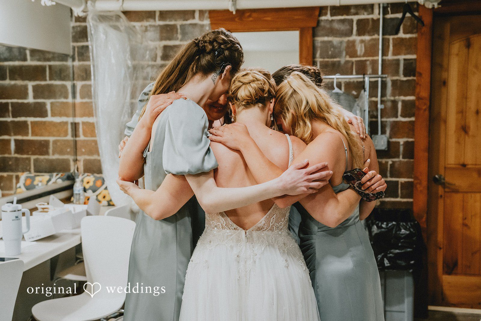 Neil + Hallie A group of bridesmaids hugging each other tightly before the ceremony