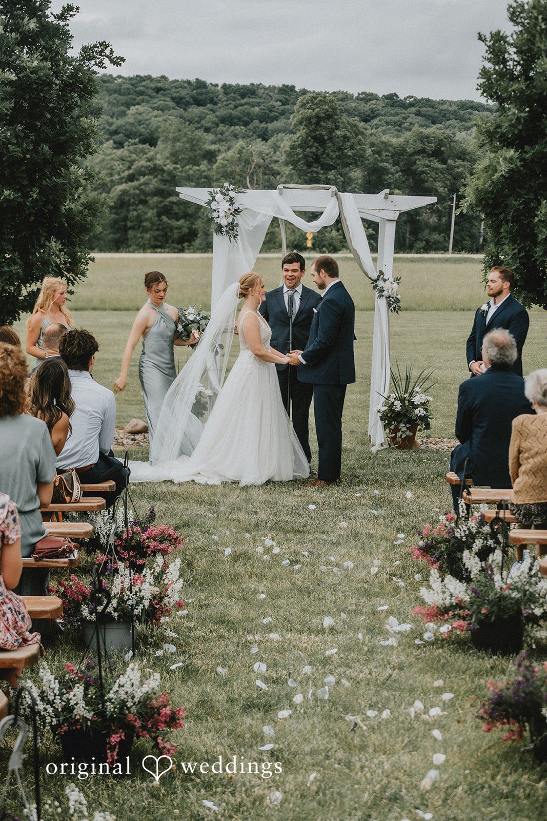 Neil + Hallie A bride and groom exchanging vows under an open-air archway during their ceremony.