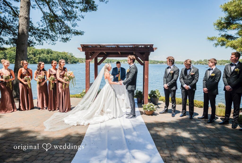 Trey + Bailey Beautiful outdoor wedding ceremony with a scenic waterfront backdrop at Blake’s Backyard captured by Detroit Wedding Photographers from Original Weddings.