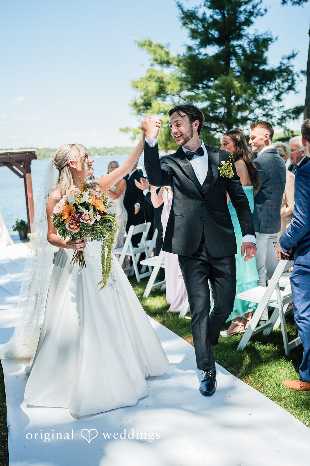 Trey + Bailey Bride smiling at her groom while holding a colourful bouquet