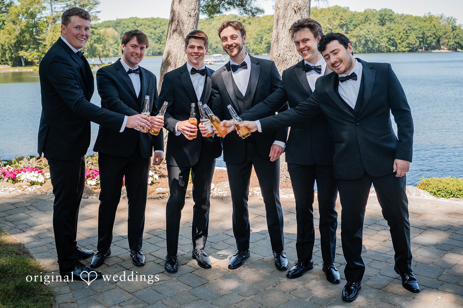 Trey + Bailey Groom celebrating with his groomsmen beside the lake at Blake's Backyard