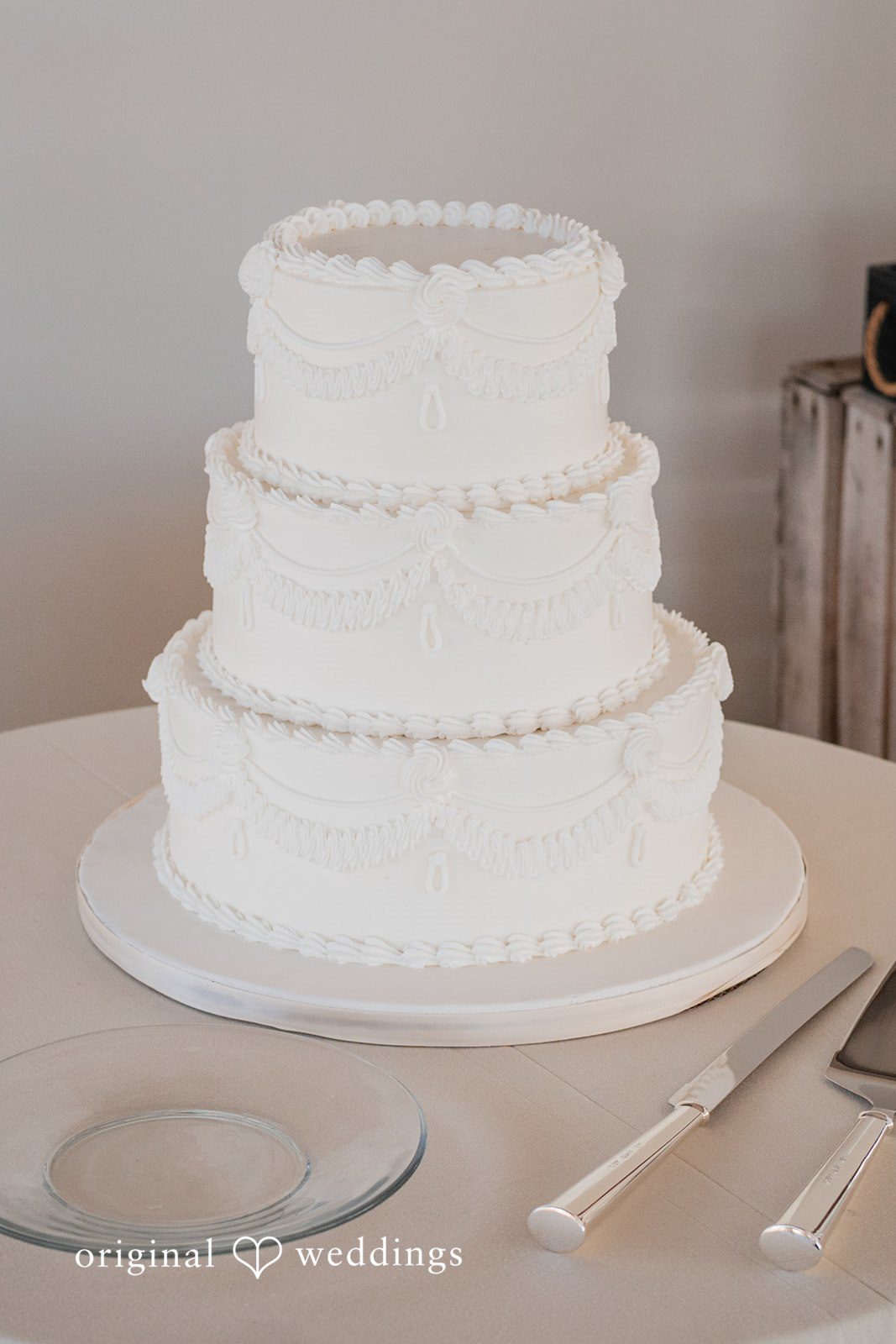 Trey + Bailey Three tier white wedding cake displayed during the reception at Blake's Backyard.