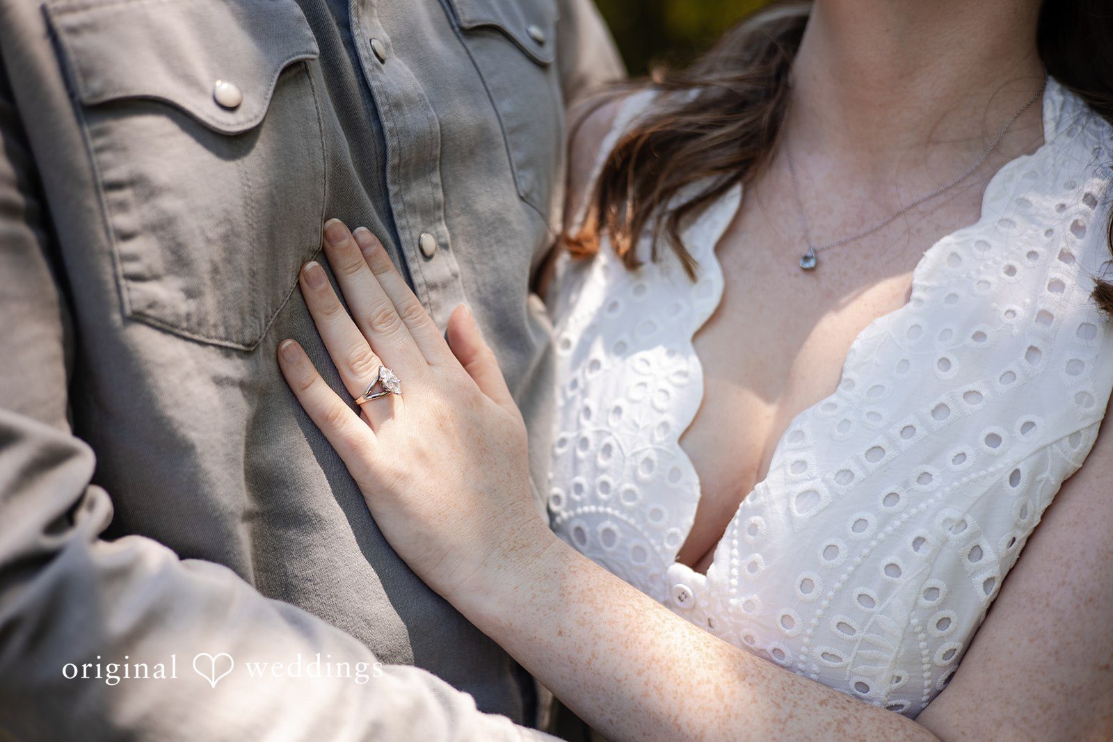 Bride placing her hand on the groom's chest while showing engagement ring at Borderland State Park