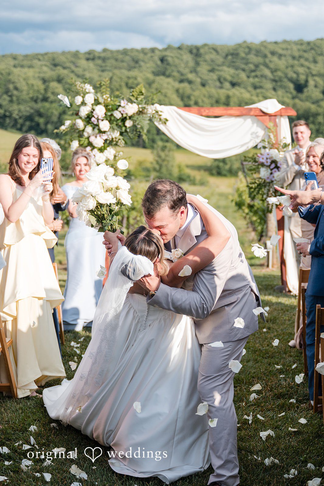 Brett + Ava Couple sharing a kiss with guests around