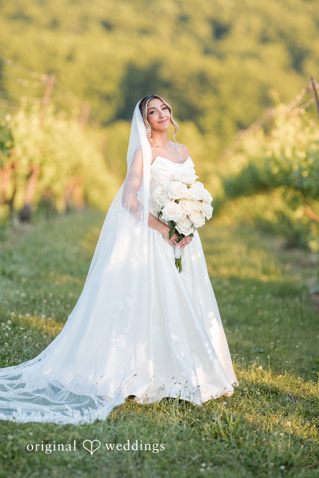 Brett + Ava Lovely pose of bride in her wedding gown holding bouquet at Breaux Vineyards