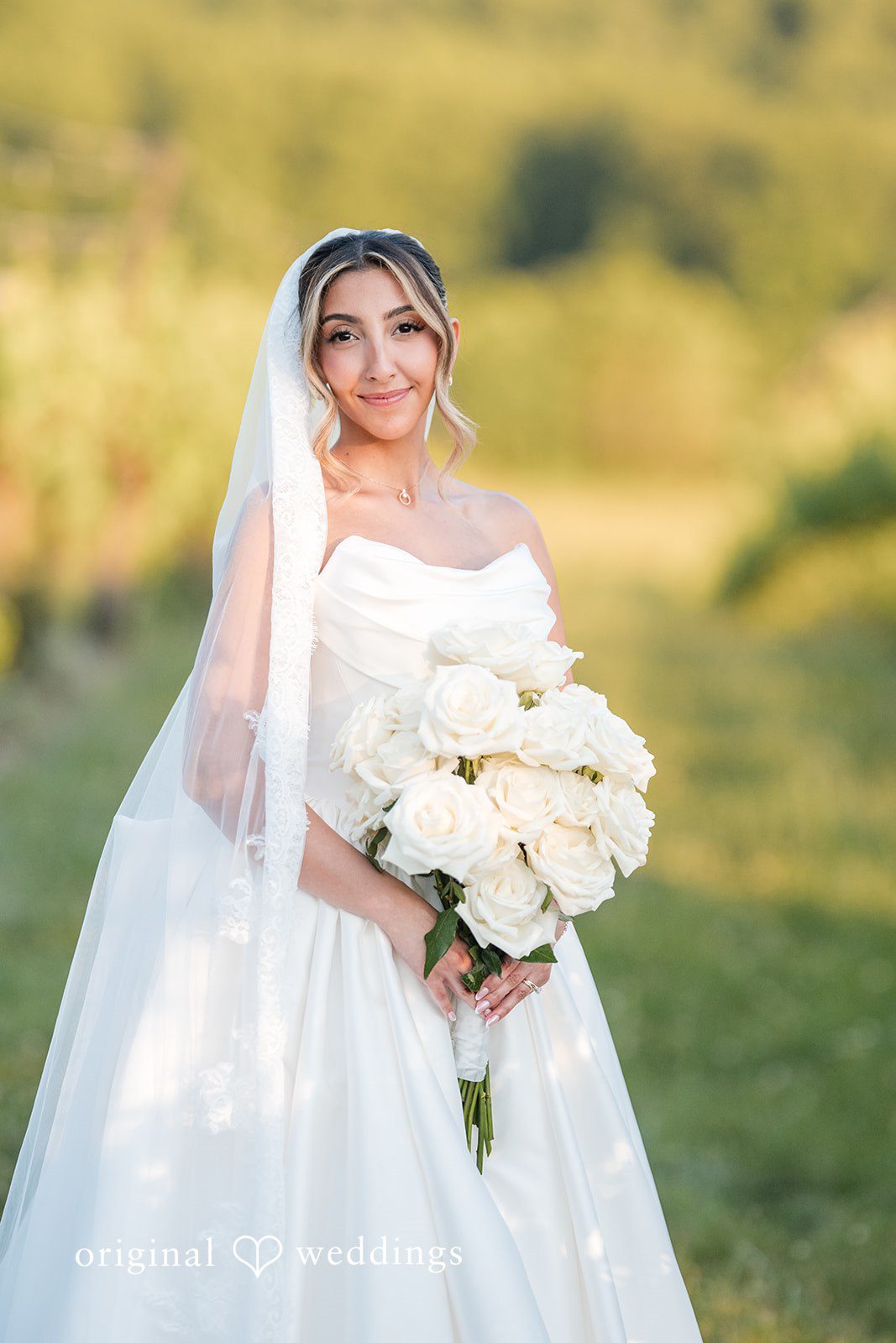 Brett + Ava Lovely pose of bride in her wedding gown holding bouquet at Breaux Vineyards