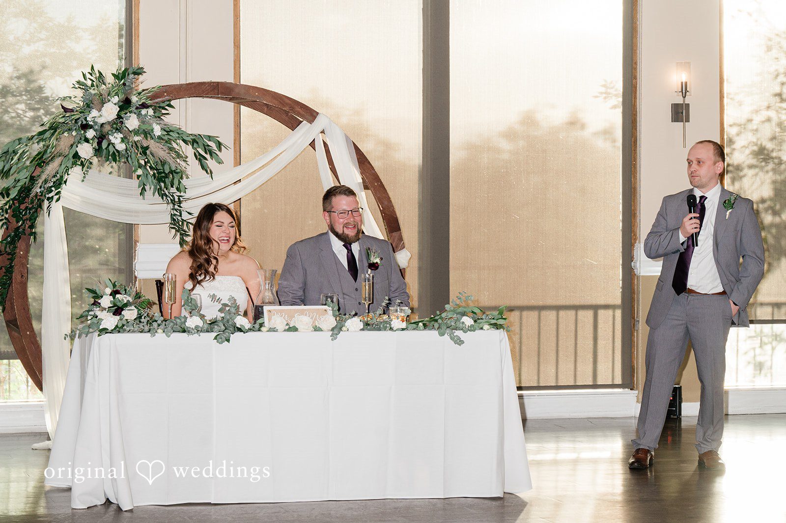 Carolina + Jonah Denver Wedding Photographers capturing couple sitting at the reception table and smiling at Brittany Hill - Wedgewood Weddings by Original Weddings