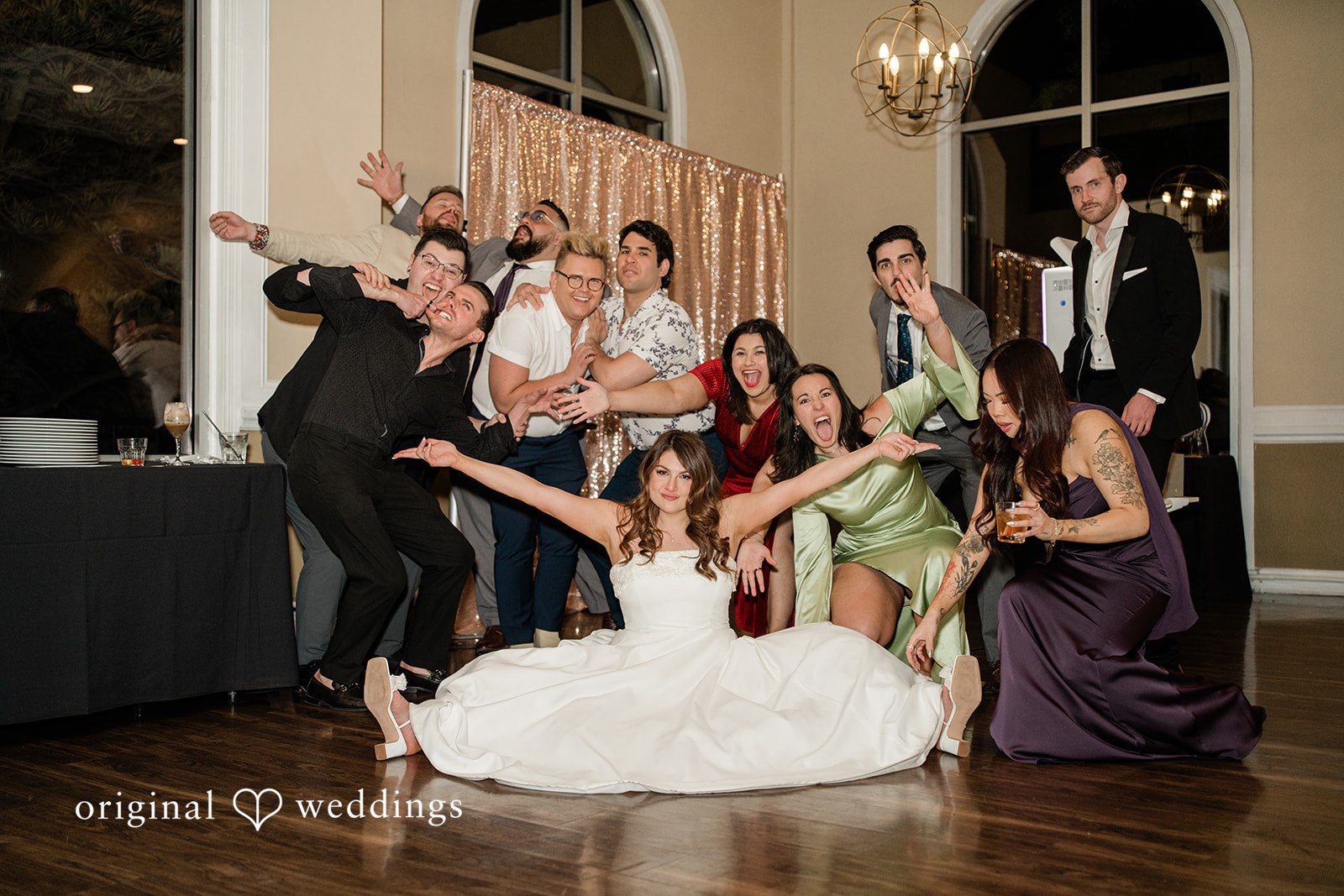 Carolina + Jonah Denver Wedding Photographers capturing couple sitting and enjoying on the floor with bridesmaids and groomsmen at Brittany Hill - Wedgewood Weddings by Original Weddings