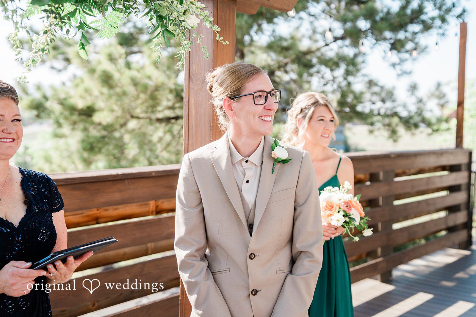 Rachel & Krystal A person wearing a tan suit standing during a wedding ceremony.
