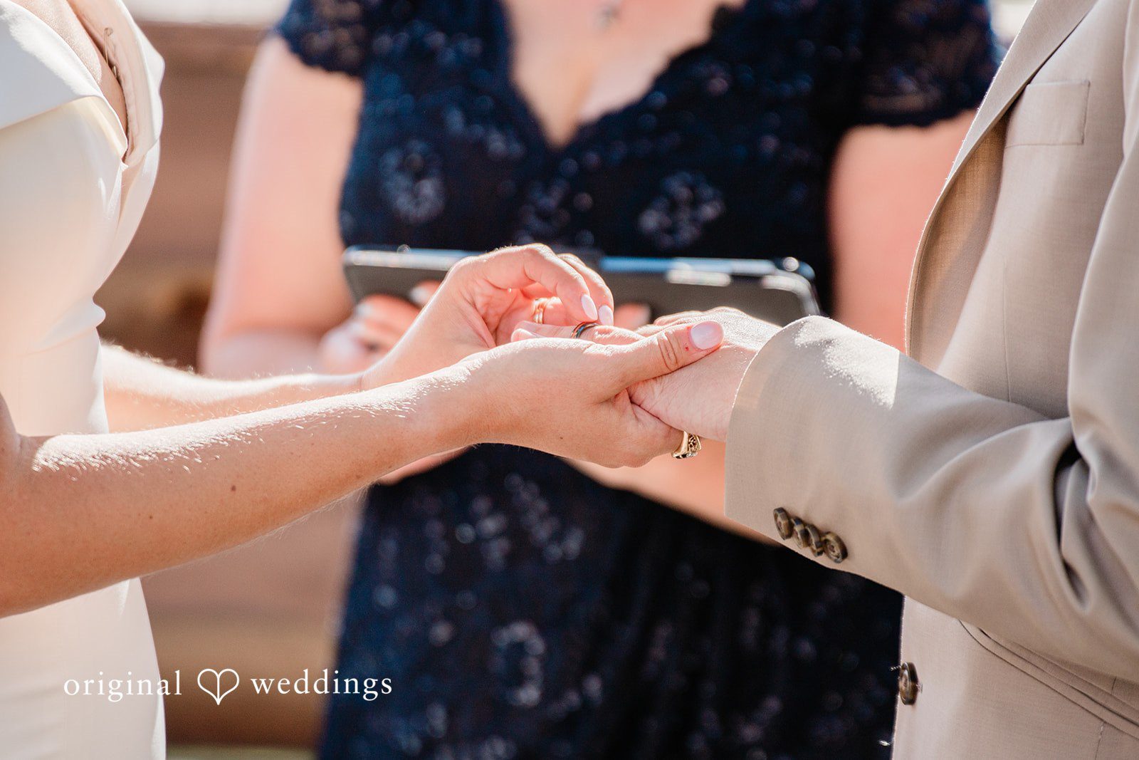Rachel & Krystal A close-up shot of a couple exchanging wedding rings.