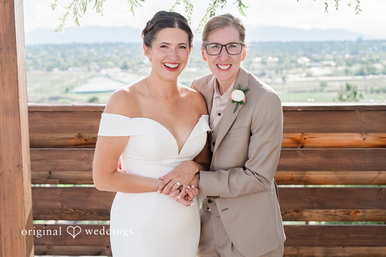 Rachel & Krystal A wedding couple posing closely together while smiling for a portrait.