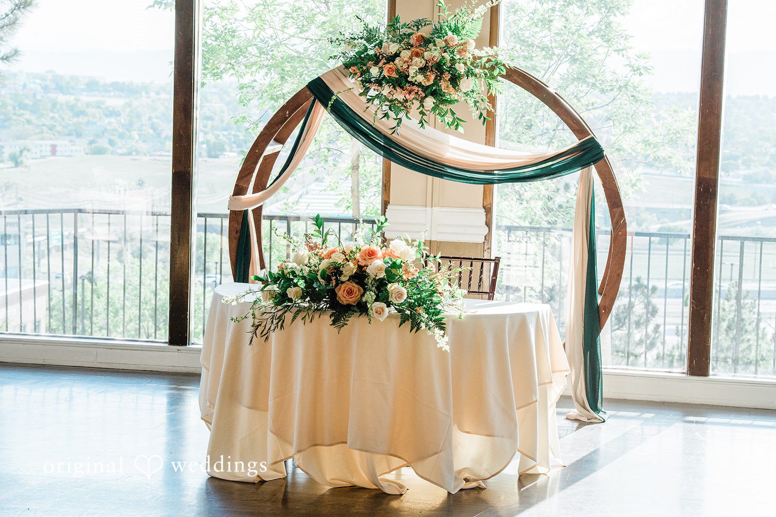 Rachel & Krystal A decorated reception table with a circular arch backdrop.