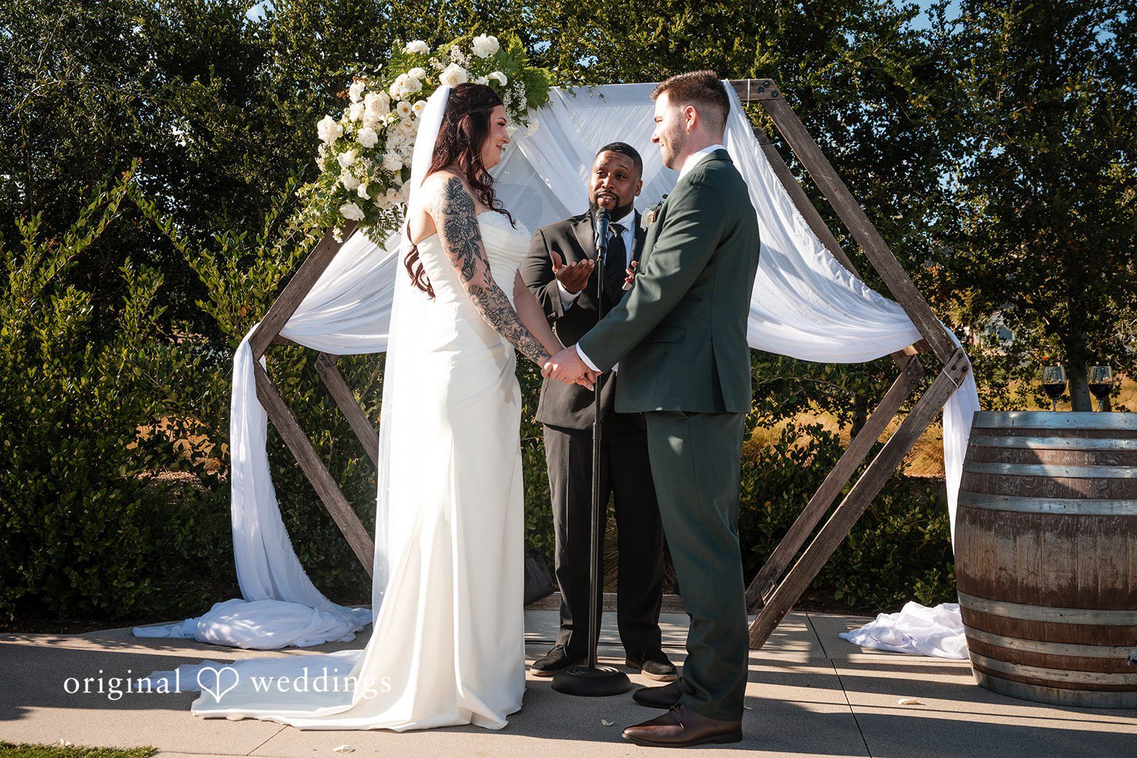 Noah + Jade A bride and groom facing each other and holding hands at wedding altar.
