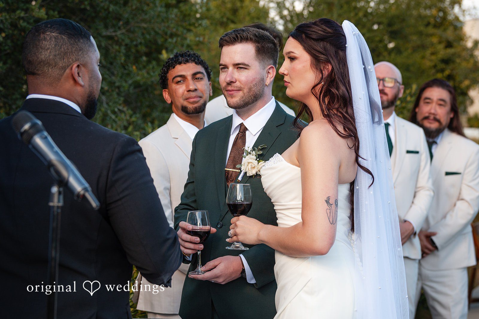 Noah + Jade A bride and groom sharing a candid moment and holding a glass during their reception.