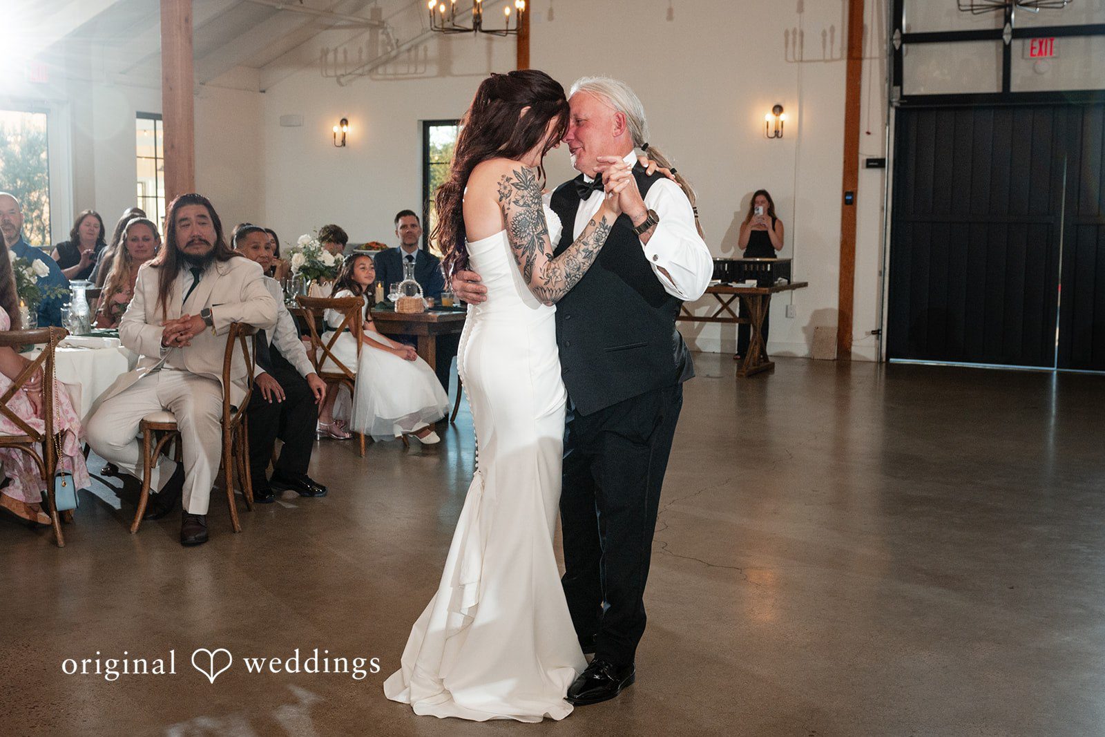 Noah + Jade A bride sharing a dance with an older man in a vest during a wedding reception.