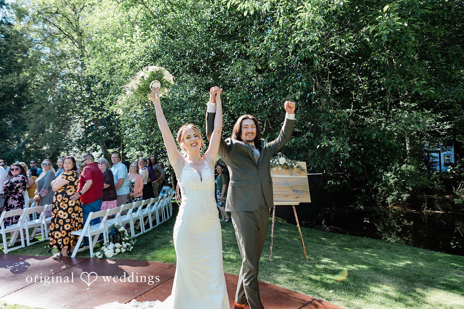 Jennifer + Steven Couple walking outside with both hands raised at cedar springs
