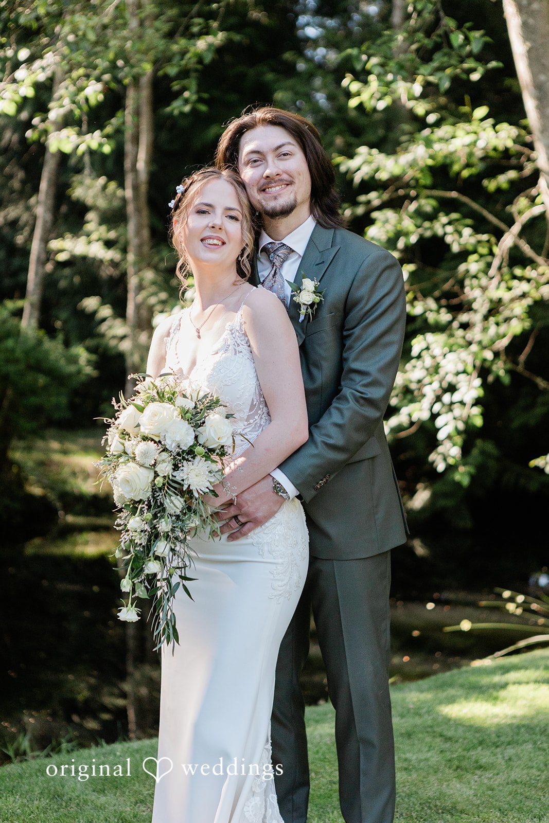 Jennifer + Steven Bride standing in front as the groom embraces her from behind at cedar springs