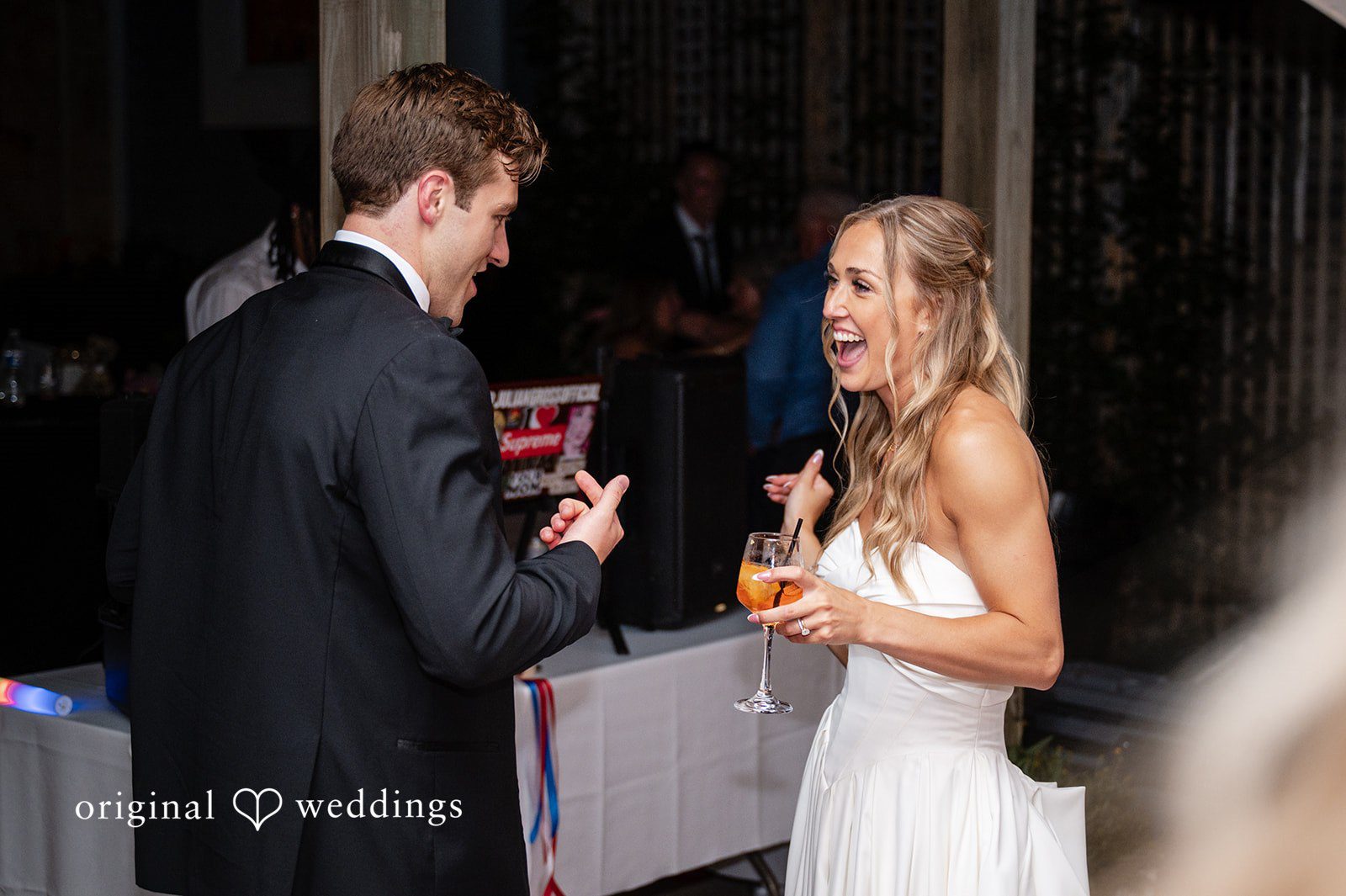 Brandi + Ryan Bride and groom laughing together while enjoying drinks during the evening reception