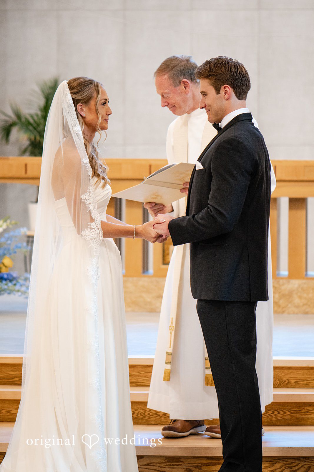 Brandi + Ryan Couple smiling and holding hands during ceremony at Christ the Lord Lutheran Church