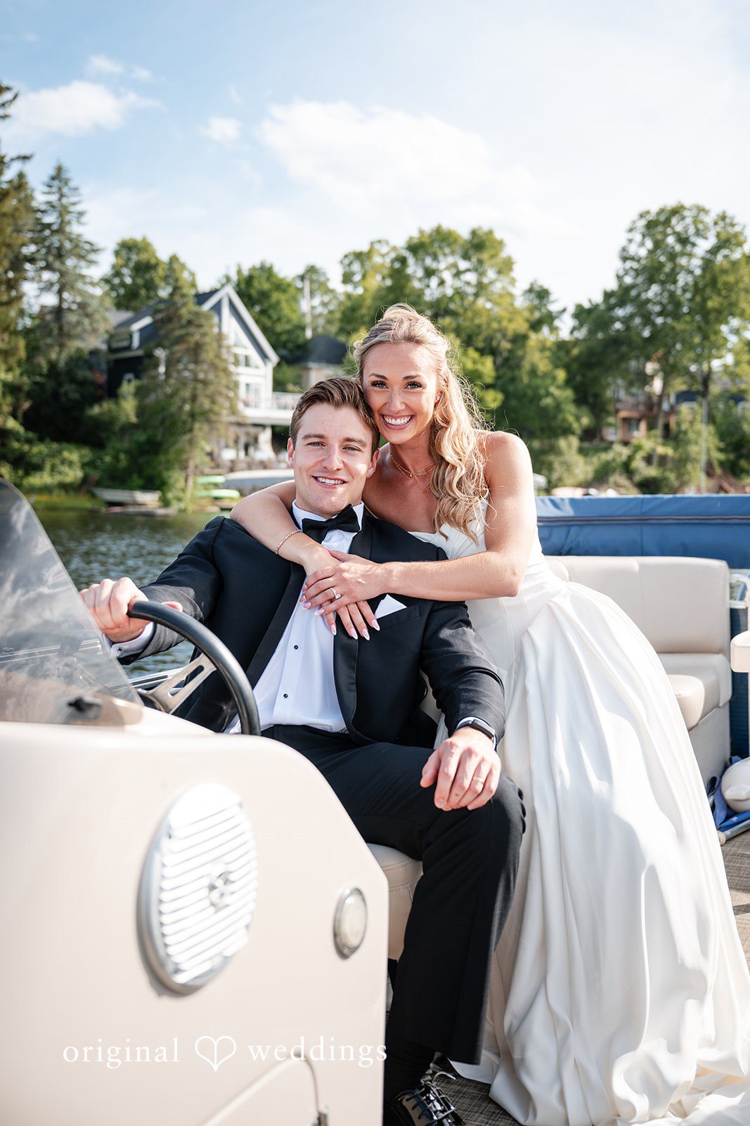 Brandi + Ryan Bride hugging the groom while he steers the boat during their wedding portraits