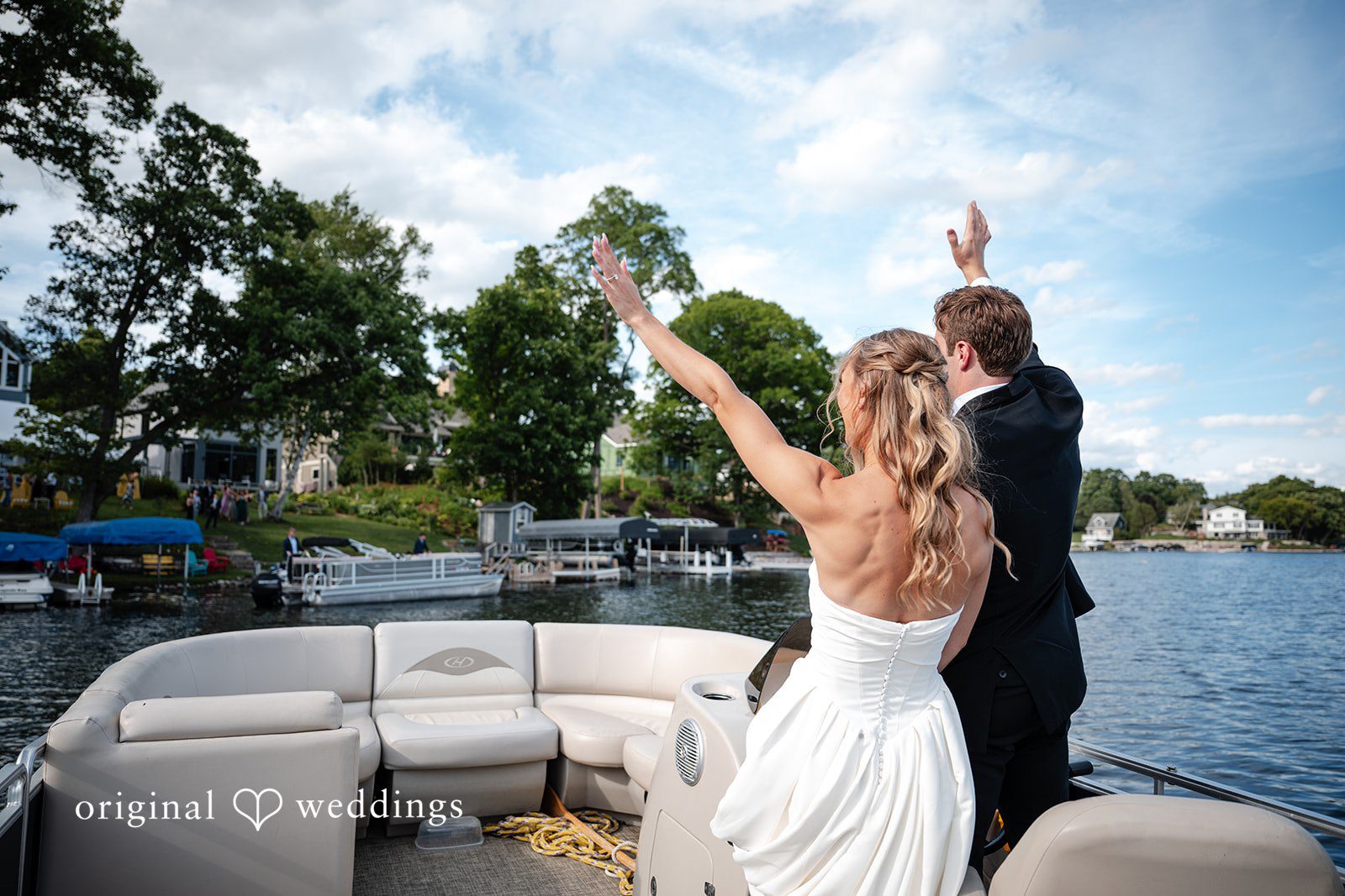 Brandi + Ryan Newlyweds celebrating together aboard a boat with waterfront homes in the background