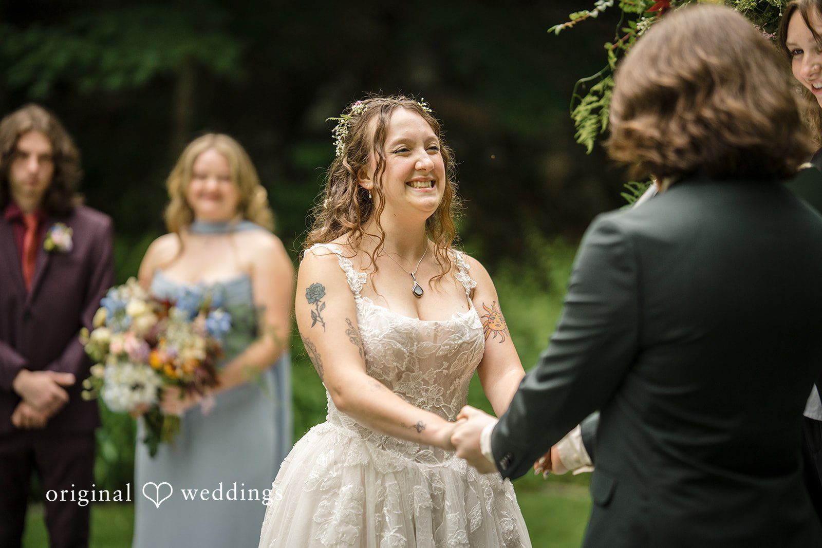 Meghan + Rowan A smiling bride holds hands with her groom at the altar during their wedding ceremony.