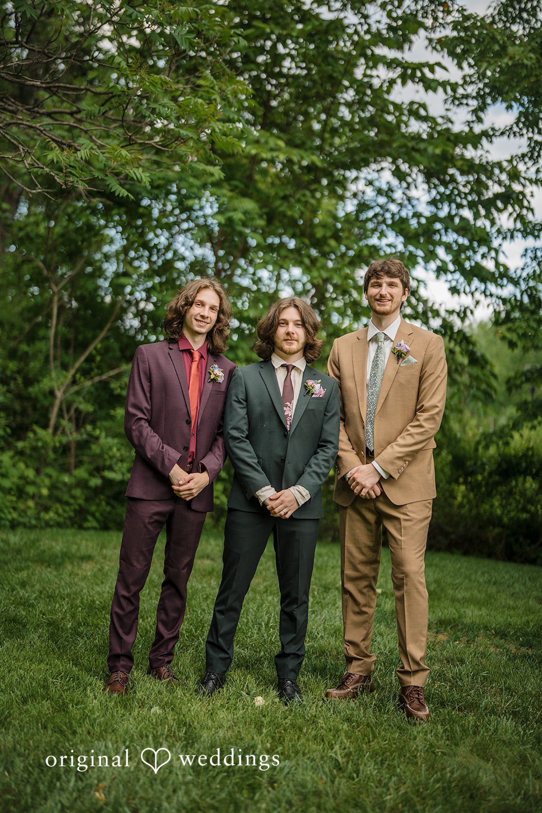 Meghan + Rowan Groomsmen posing together in distinct plum, dark grey, and tan colored suits.