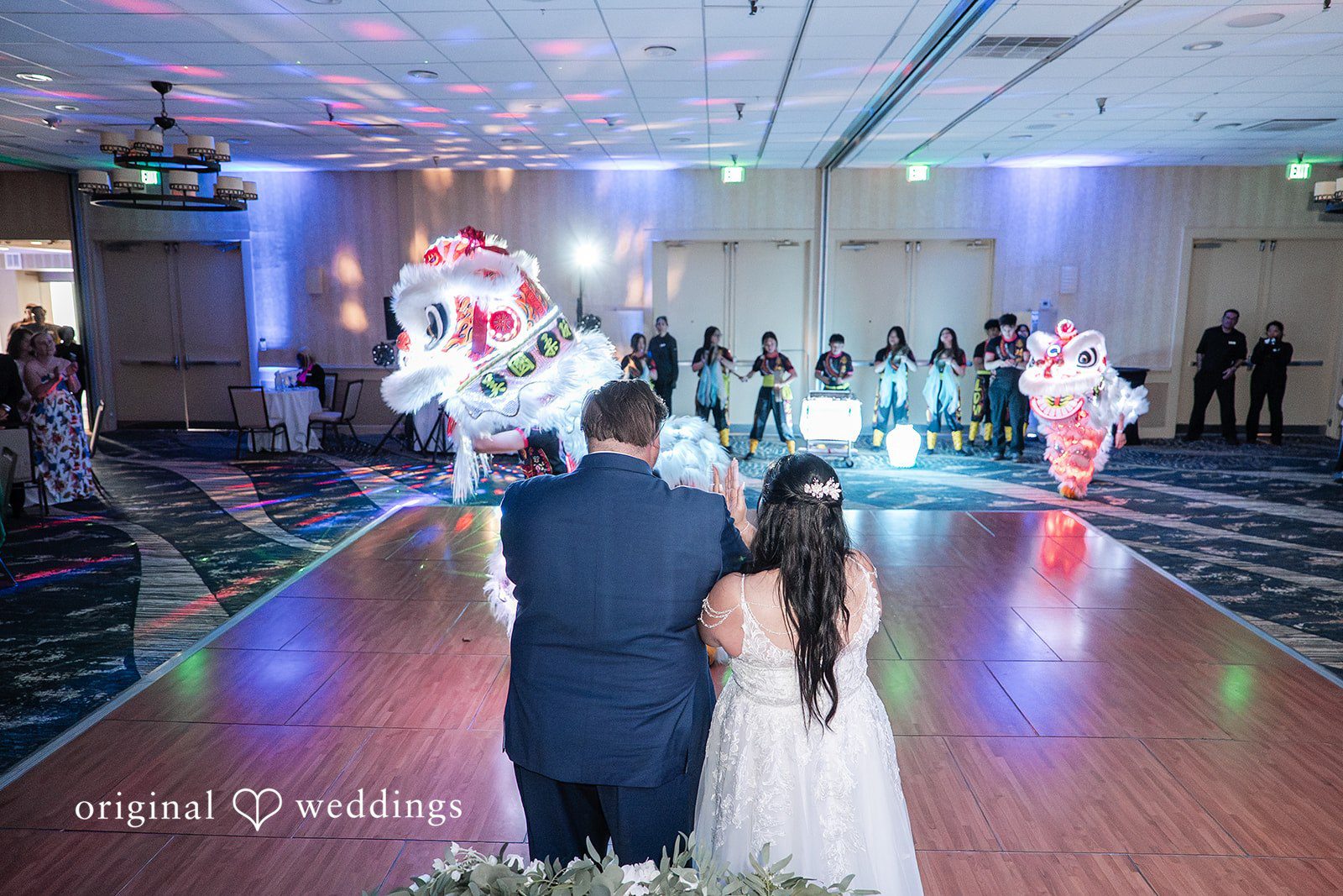 Thuy + Ryan Bride and groom watching the lion dance performance during their reception.