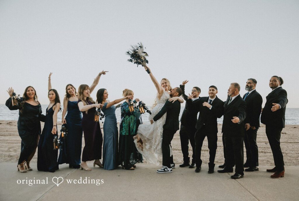 Allison + Justin San Antonio Wedding Photographers capturing groom lifting the bride with bridesmaids and groomsmen at DoubleTree by Hilton Corpus Christi Beachfront by Original Weddings
