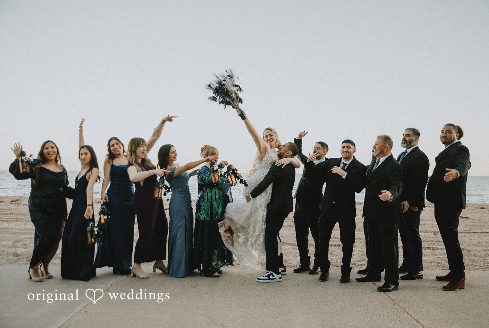 San Antonio Wedding Photographers capturing groom lifting the bride with bridesmaids and groomsmen at DoubleTree by Hilton Corpus Christi Beachfront by Original Weddings