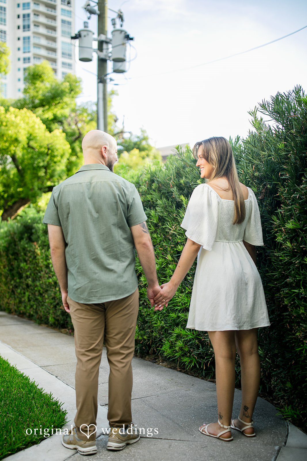Lauren + Miles A couple holding hands while walking away along a path.