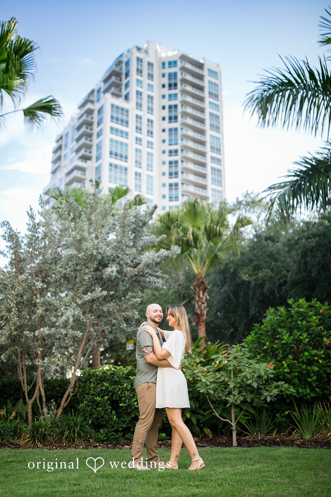 Lauren + Miles A wide shot of a couple walking near tall buildings.
