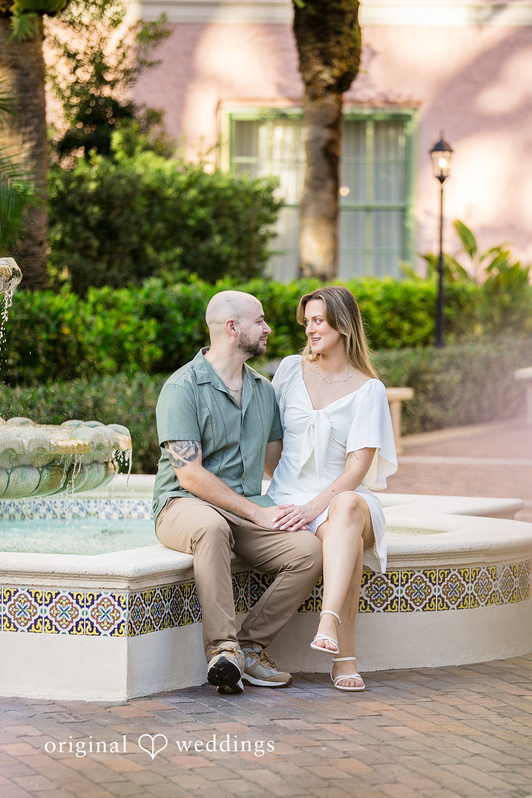 Lauren + Miles A couple sitting together on a concrete ledge.
