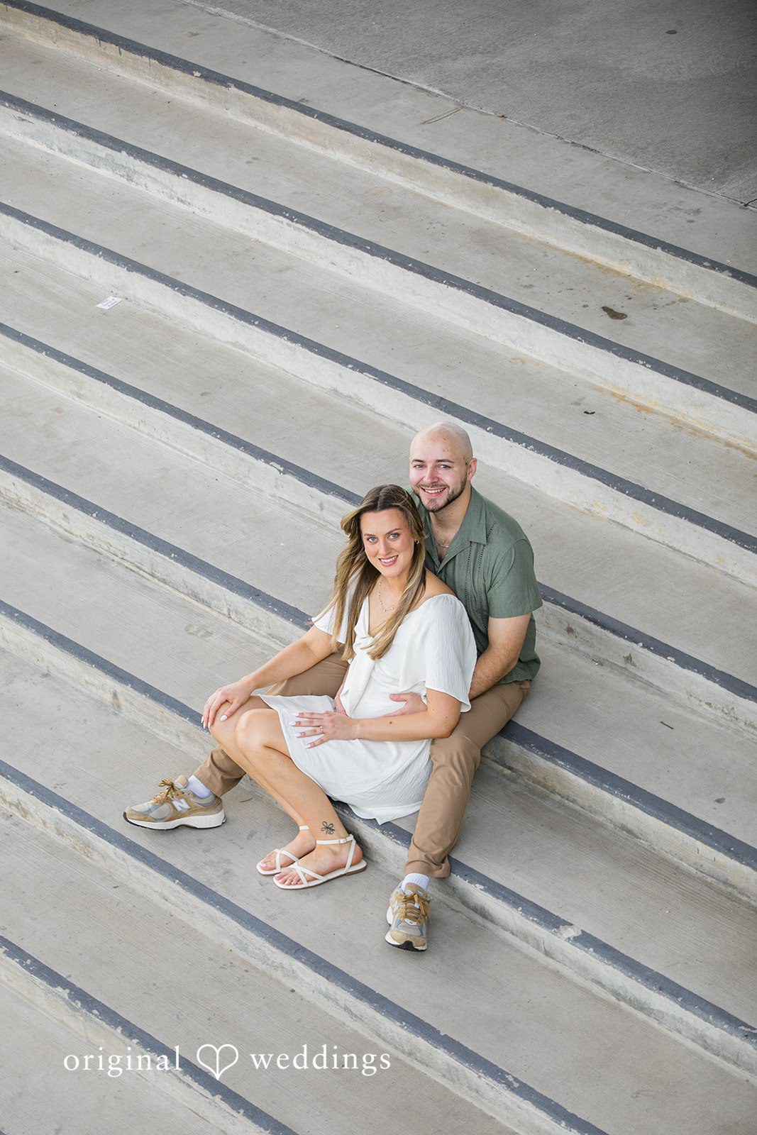 Lauren + Miles An aerial view of a couple sitting on wide concrete steps.
