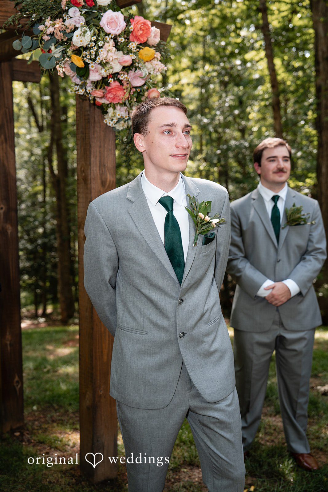 Conner + Ashley A groom in a grey suit and green tie standing next to a groomsman.