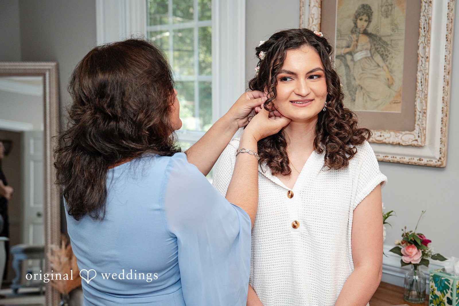 Conner + Ashley A woman assisting the bride with putting on her earrings.