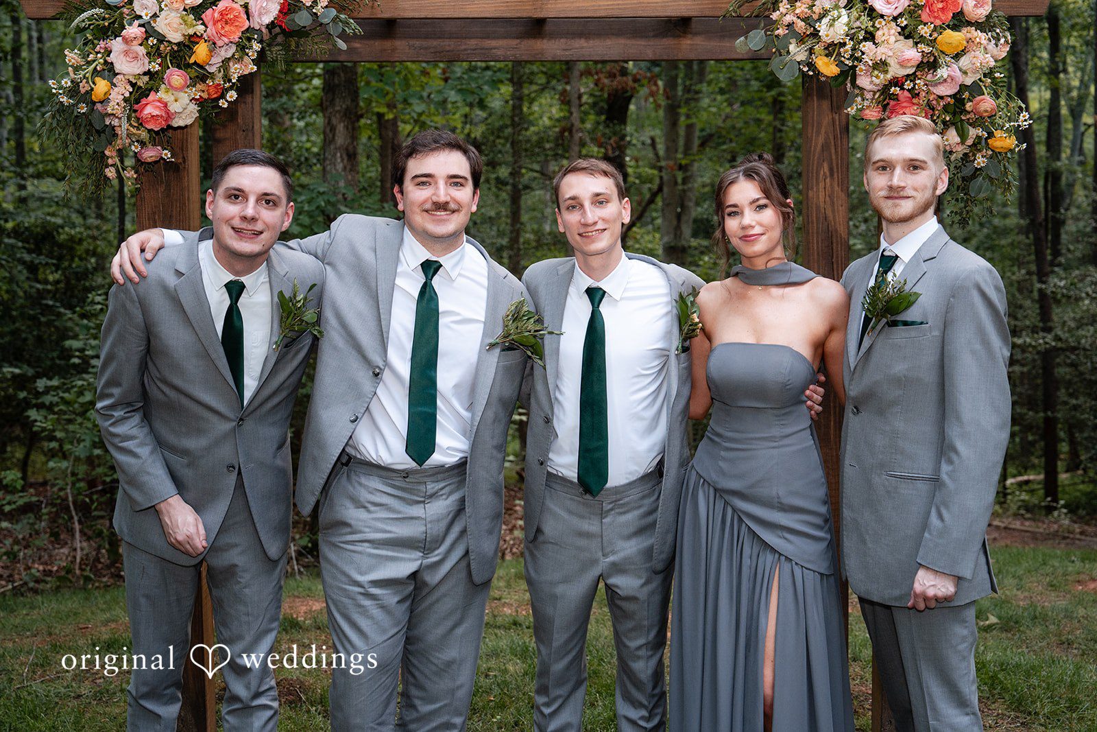 Conner + Ashley Groomsmen in grey suits smiling and posing together with a bridesmaid in a grey dress.